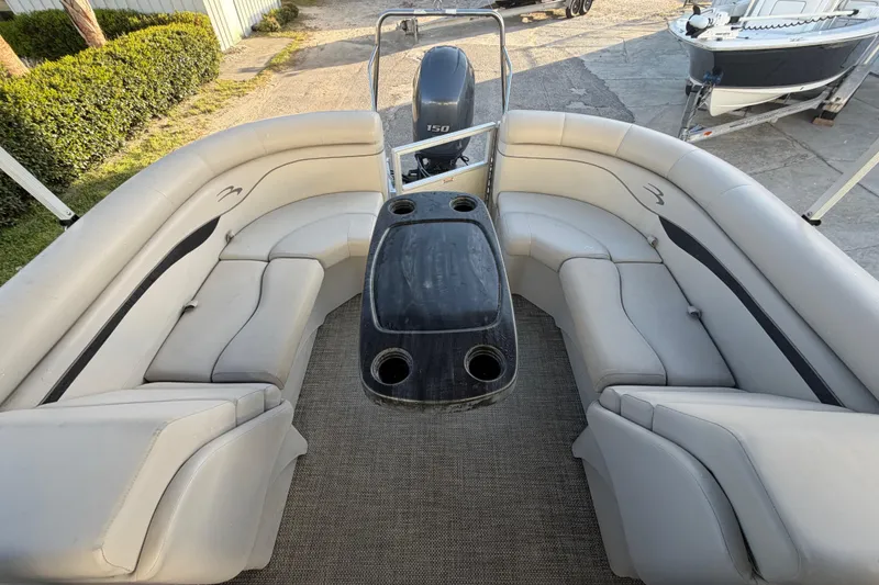 Slide: The Image of 2016 Bennington 22 SX pontoon boat interior with plush seating and central table. - 36