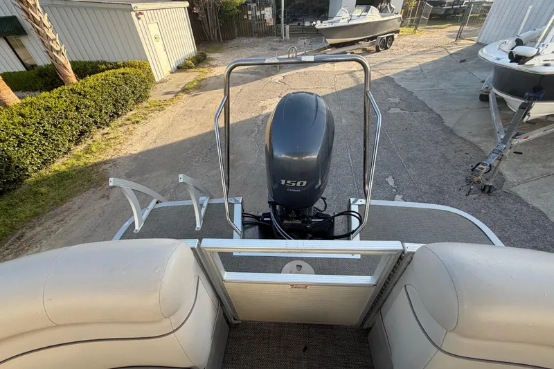 Slide: The Image of 2016 Bennington 22 SX pontoon boat with Yamaha 150 engine, parked outdoors. - 40