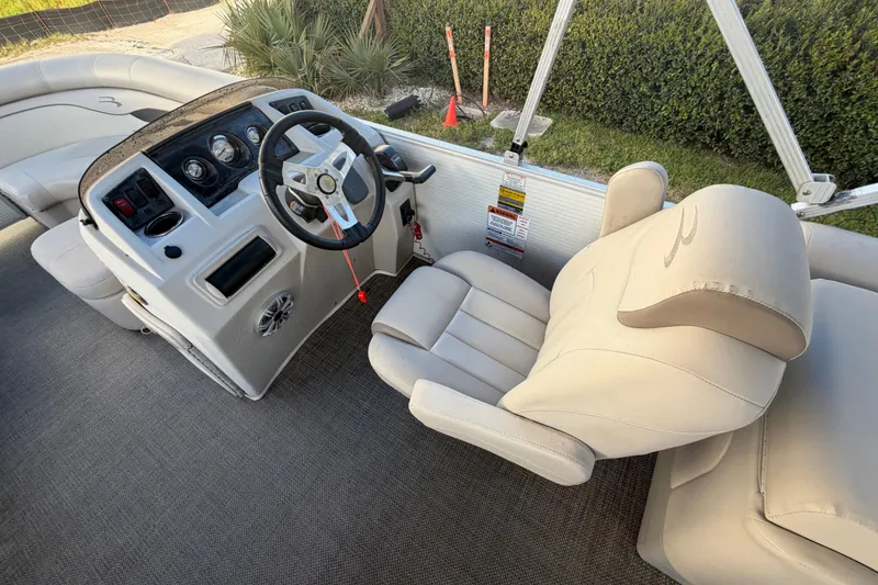 Slide: The Image of 2016 Bennington 22 SX boat interior with steering console and beige seating. - 46
