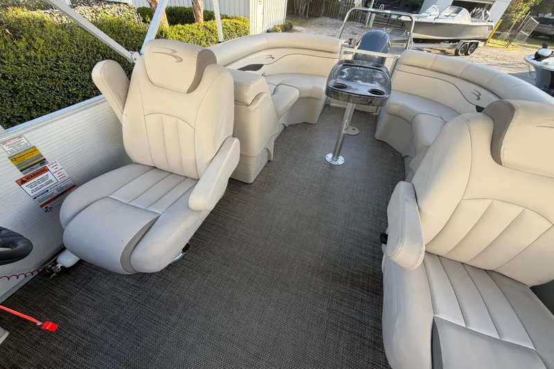 Slide: The Image of 2016 Bennington 22 SX pontoon boat interior with beige seating and table. - 53