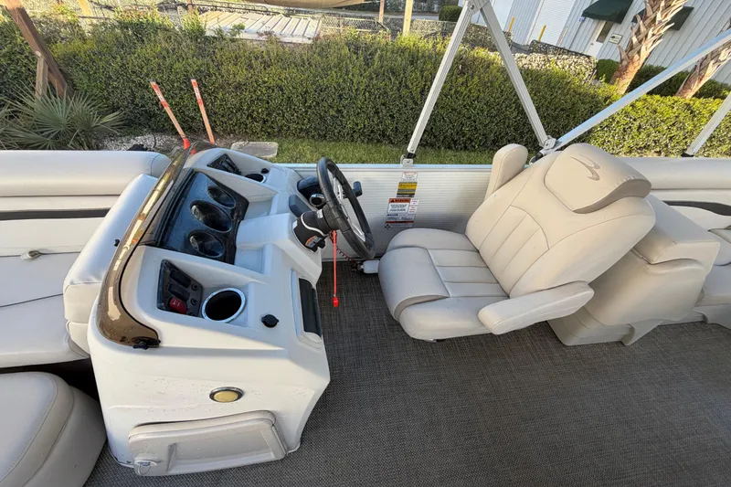 Slide: The Image of 2016 Bennington 22 SX boat interior with steering console and beige seating. - 54
