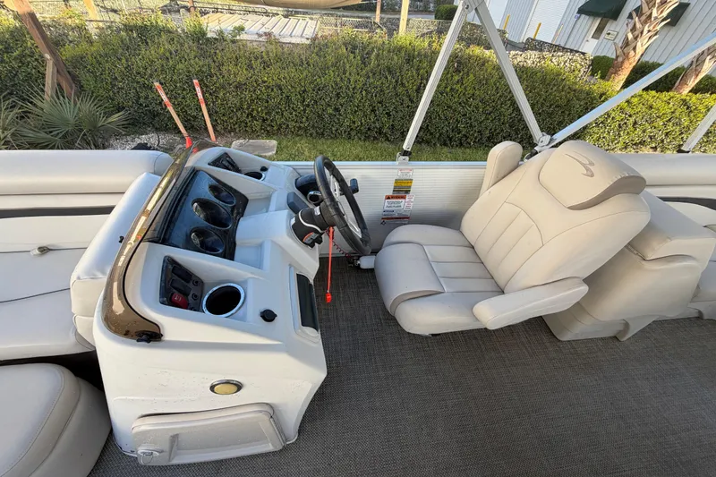 Slide: The Image of 2016 Bennington 22 SX boat interior with steering console and beige seating. - 55