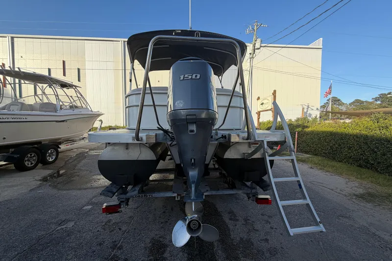 Slide: The Image of 2016 Bennington 22 SX pontoon boat with 150 HP engine, parked outdoors. - 6