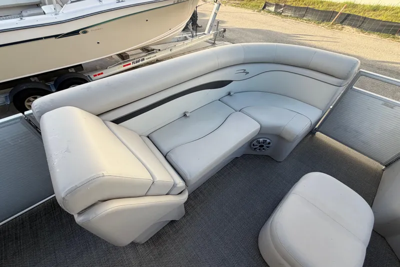 Slide: The Image of 2016 Bennington 22 SX pontoon boat interior with gray seating and carpeted flooring. - 60