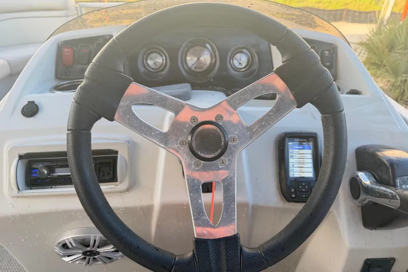 Slide: The Image of Steering wheel and dashboard of 2016 Bennington 22 SX boat with gauges and controls. - 72