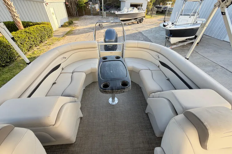 Slide: The Image of 2016 Bennington 22 SX pontoon boat interior with beige seating and central table. - 74