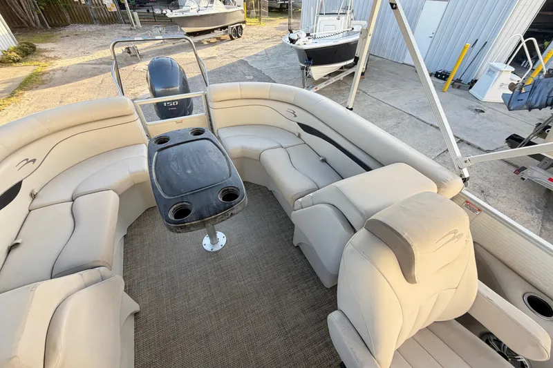 Slide: The Image of 2016 Bennington 22 SX pontoon boat interior with beige seating and central table. - 76