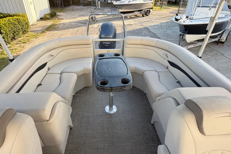 Slide: The Image of 2016 Bennington 22 SX pontoon boat interior with beige seating and central table. - 77