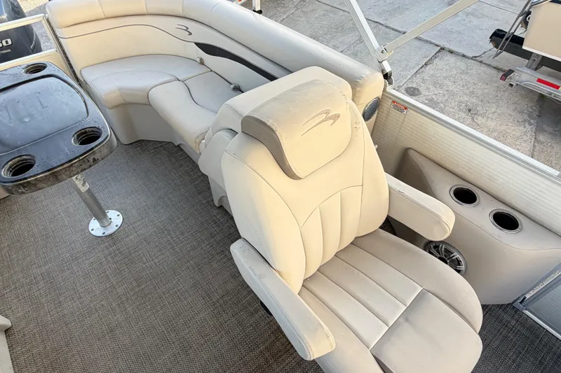 Slide: The Image of 2016 Bennington 22 SX boat interior with beige seating and cup holders. - 78