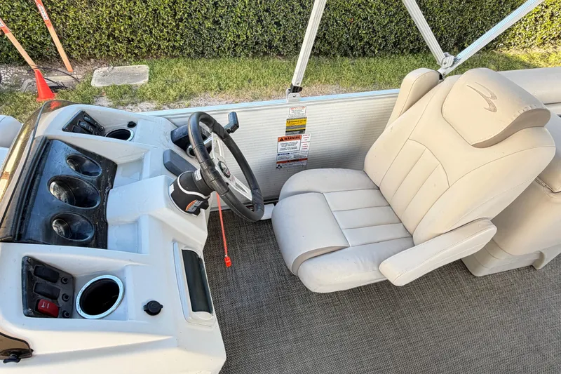 Slide: The Image of 2016 Bennington 22 SX boat interior with steering wheel and captain's chair. - 80