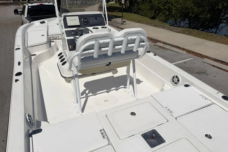Slide: The Image of 2018 Epic 22SC boat interior with console and seating, parked on a street. - 11