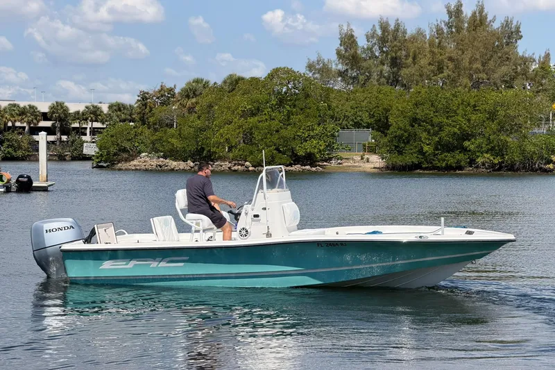 Slide: The Image of 2018 Epic 22SC boat with Honda engine cruising on a calm waterway. - 23