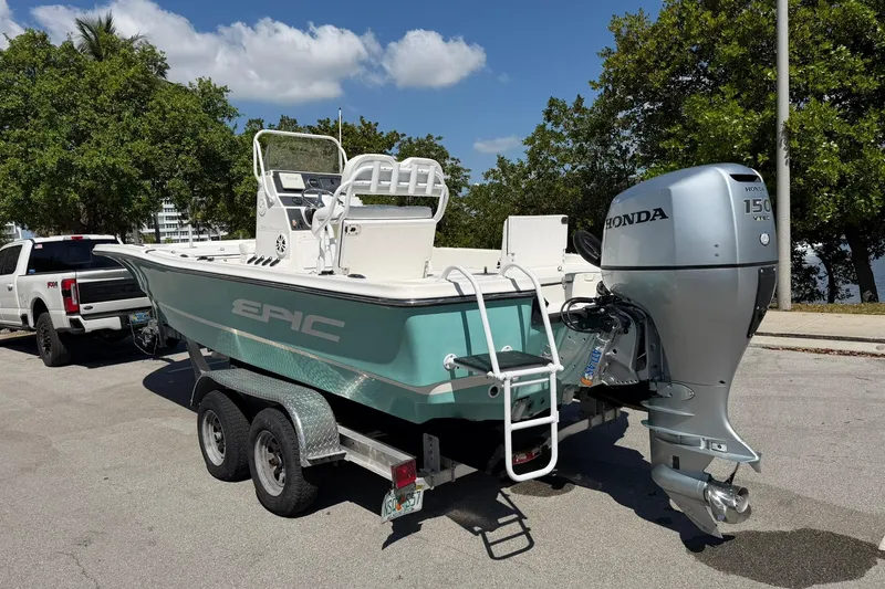 Slide: The Image of 2018 Epic 22SC boat on trailer with Honda 150 outboard motor, parked outdoors. - 5