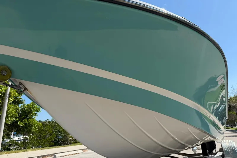 Slide: The Image of 2018 Epic 22SC boat hull with teal and white design under clear blue sky. - 8