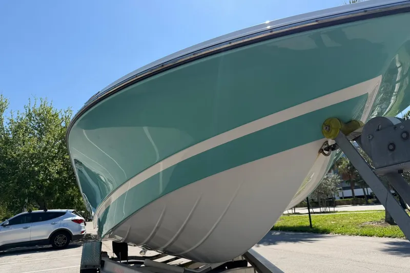 Slide: The Image of 2018 Epic 22SC boat on trailer, teal and white hull, sunny day. - 9