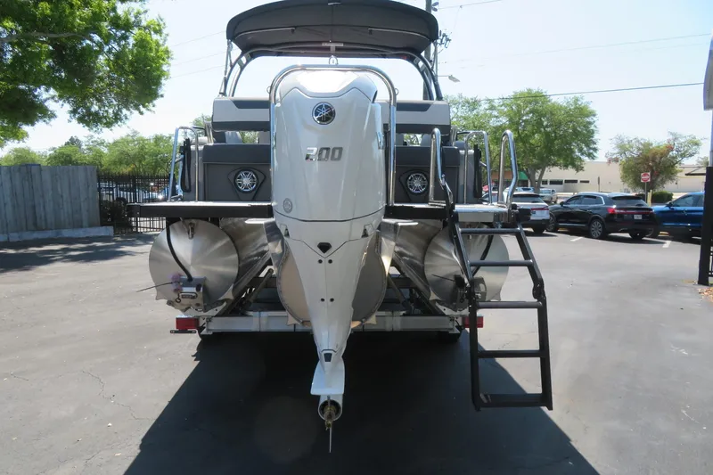 Slide: The Image of 2026 Avalon Catalina Quad Lounge Shift boat rear view with powerful engine and ladder. - 14