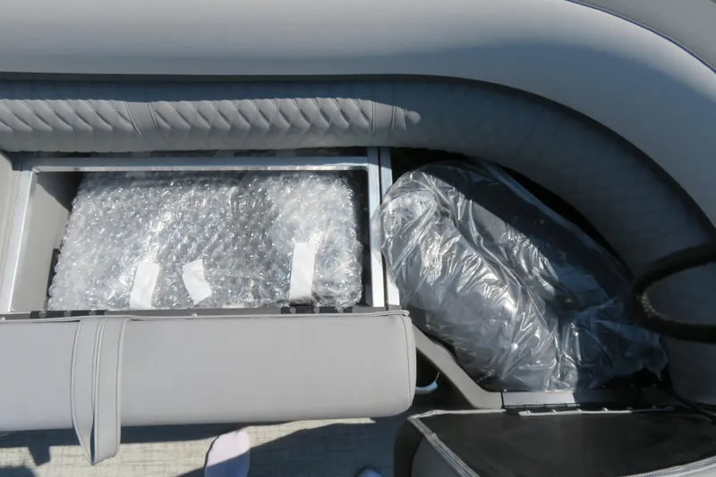 Slide: The Image of 2026 Avalon Catalina Quad Lounge boat seat storage with bubble wrap and protective covers. - 40