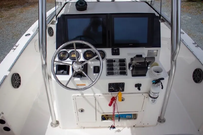 Slide: The Image of Center console of 2001 Cobia 274 boat with steering wheel and dual screens. - 10