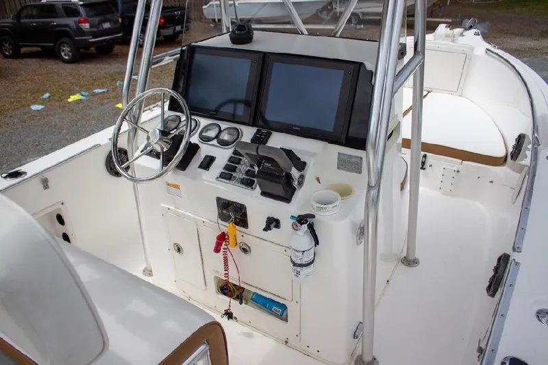 Slide: The Image of 2001 Cobia 274 Center Console boat dashboard with steering wheel and navigation screens. - 12
