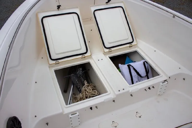 Slide: The Image of Open storage compartments on a 2001 Cobia 274 Center Console boat, containing anchor and gear. - 17