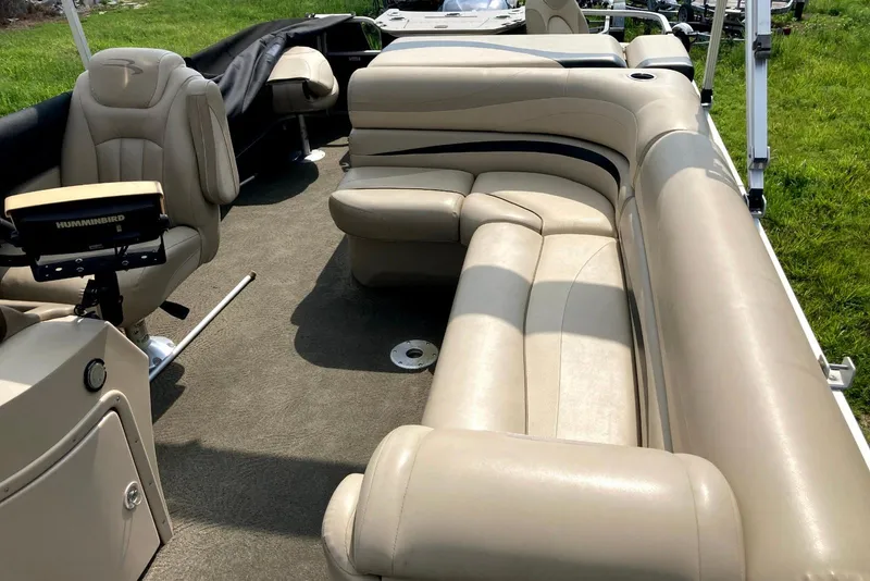 Slide: The Image of 2013 Bennington 2574 GL pontoon boat interior with beige seating and steering console. - 1