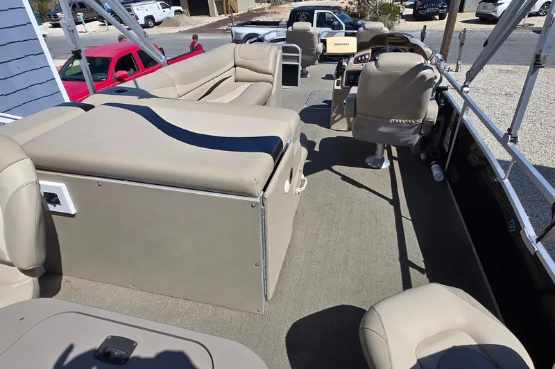 Slide: The Image of 2013 Bennington 2574 GL pontoon boat interior with beige seating and steering console. - 10