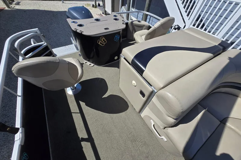 Slide: The Image of 2013 Bennington 2574 GL pontoon boat interior with beige seating and helm station. - 12