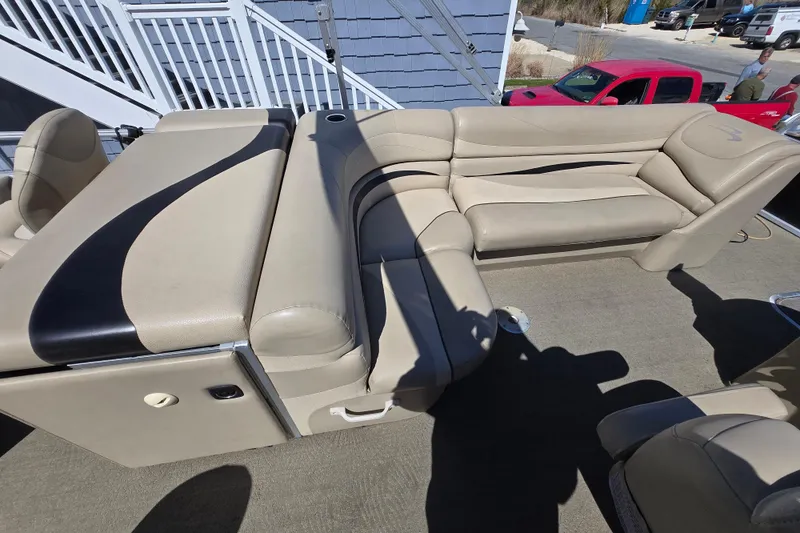 Slide: The Image of 2013 Bennington 2574 GL boat interior with beige seating and black accents. - 13