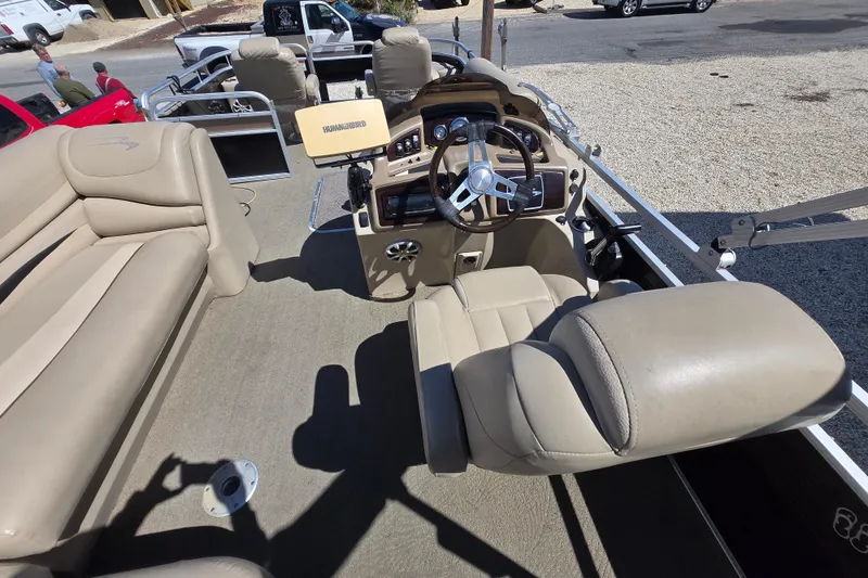 Slide: The Image of Interior of a 2013 Bennington 2574 GL pontoon boat with beige seating and steering console. - 14