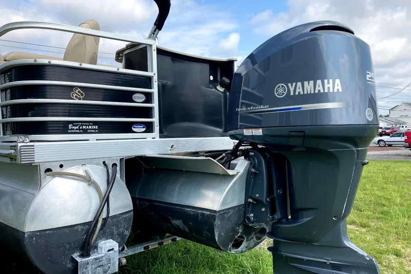 Slide: The Image of 2013 Bennington 2574 GL pontoon boat with Yamaha outboard motor on grassy area. - 2