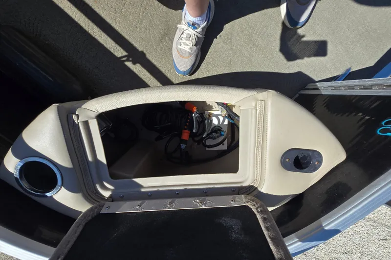 Slide: The Image of Open storage compartment on a 2013 Bennington 2574 GL boat, showing interior cables and accessories. - 23