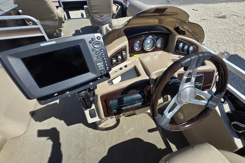 Slide: The Image of 2013 Bennington 2574 GL boat dashboard with steering wheel and Humminbird fish finder. - 24
