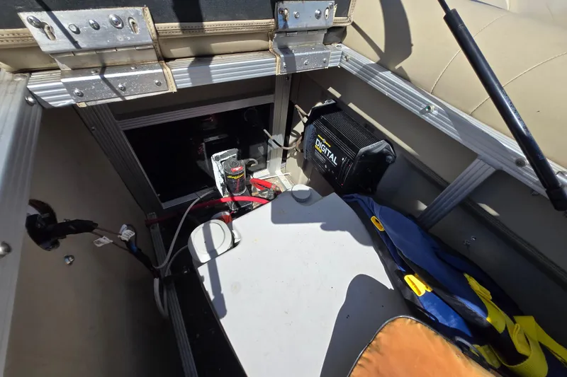 Slide: The Image of 2013 Bennington 2574 GL boat interior showing battery compartment and digital charger. - 28