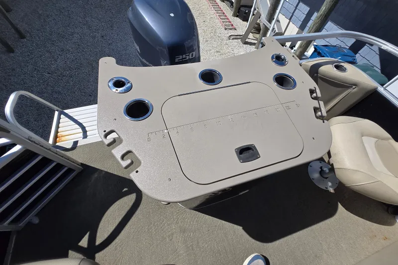 Slide: The Image of 2013 Bennington 2574 GL boat deck with seating and motor, featuring cup holders and a measuring board. - 32