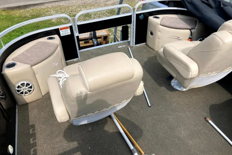 Slide: The Image of Interior of a 2013 Bennington 2574 GL pontoon boat with beige seating and cup holders. - 6