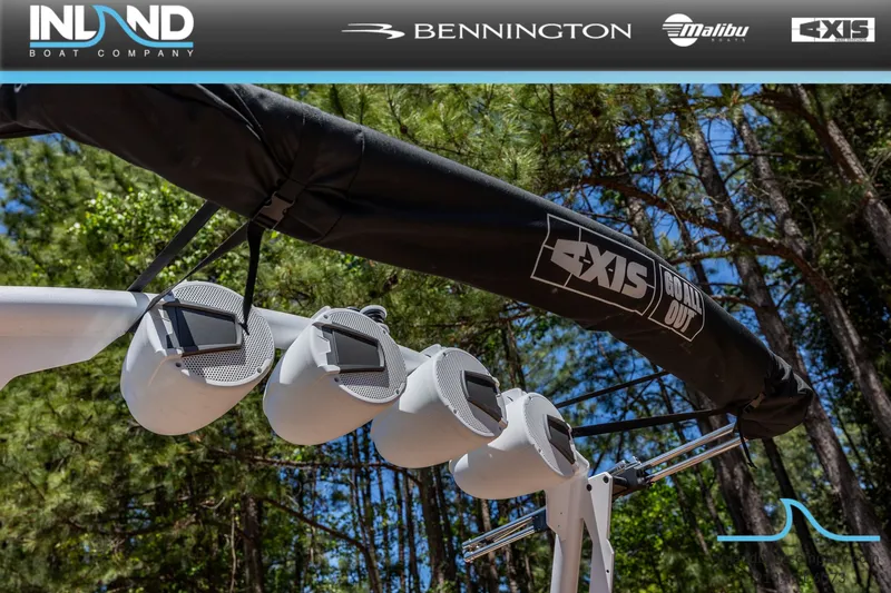 Slide: The Image of 2026 Axis T220 boat with speakers and cover in a forest setting. - 12