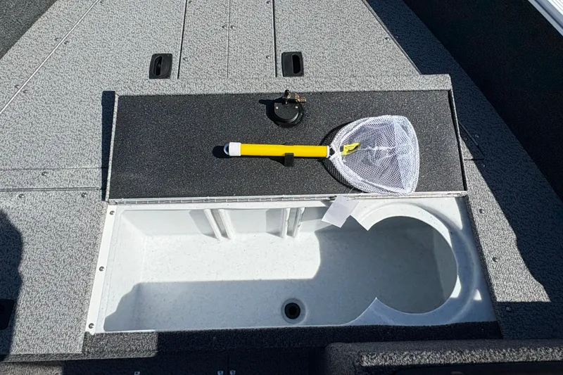 Slide: The Image of 2026 Lund 1650 Angler SS boat interior with storage compartment and fishing net. - 11