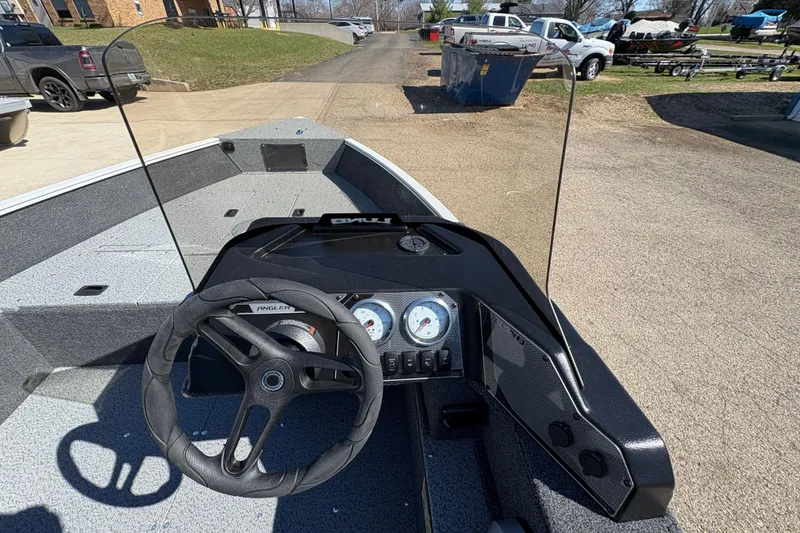 Slide: The Image of 2026 Lund 1650 Angler SS boat dashboard with steering wheel and gauges. - 13