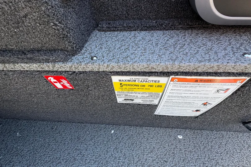 Slide: The Image of 2026 Lund 1650 Angler SS boat interior with safety and capacity labels. - 14