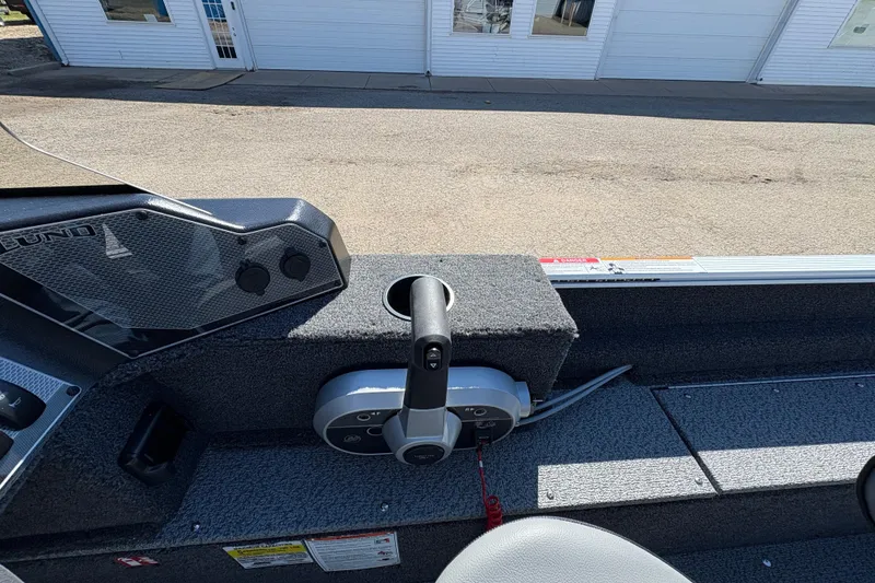 Slide: The Image of 2026 Lund 1650 Angler SS boat interior with steering controls and dashboard. - 15