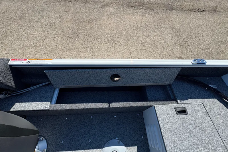 Slide: The Image of 2026 Lund 1650 Angler SS boat interior with storage compartment and textured flooring. - 18