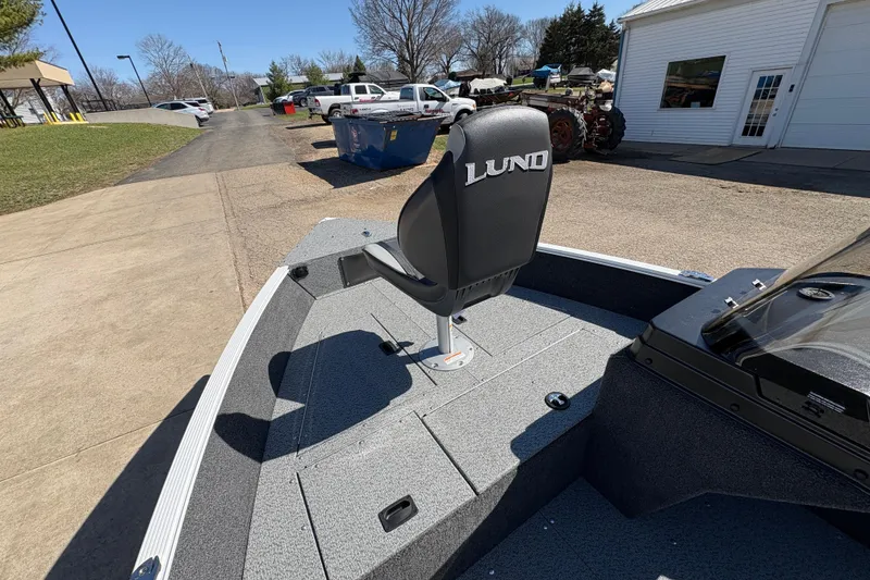 Slide: The Image of 2026 Lund 1650 Angler SS boat with swivel seat, parked outdoors. - 23
