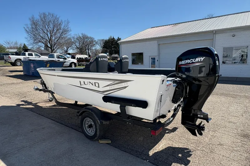 Slide: The Image of 2026 Lund 1650 Angler SS boat with Mercury engine on trailer, parked outdoors. - 3