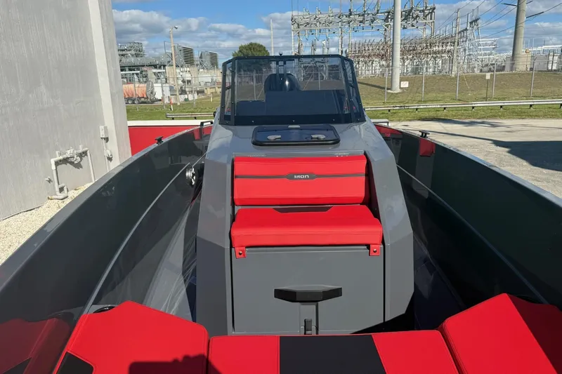 Slide: The Image of 2026 Iron 907 boat with red seating, docked near industrial area under blue sky. - 16