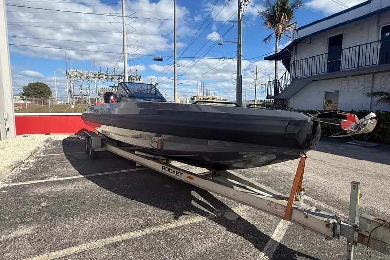 Slide: The Image of 2026 Iron 907 boat on trailer in parking lot, clear sky background. - 25
