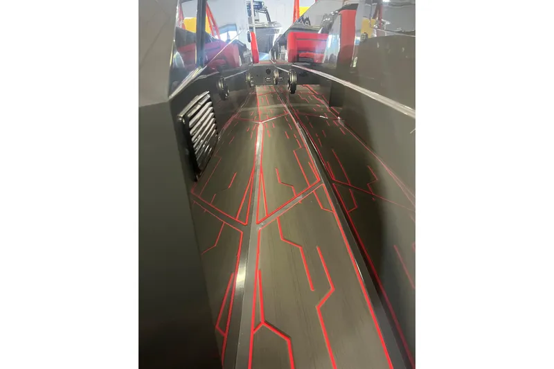 Slide: The Image of Open storage compartment on Iron 907 boat, showcasing interior components, red seating, and exterior details. - 8