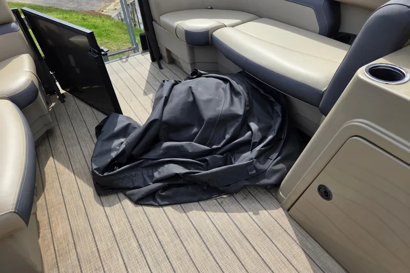 Slide: The Image of 2024 Starcraft EXS 1 boat interior with beige seating and black cover on deck. - 18