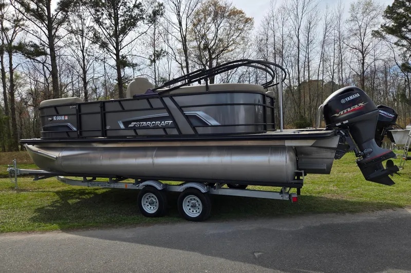 Slide: The Image of 2024 Starcraft EXS 1 pontoon boat on trailer with Yamaha outboard motor. - 2