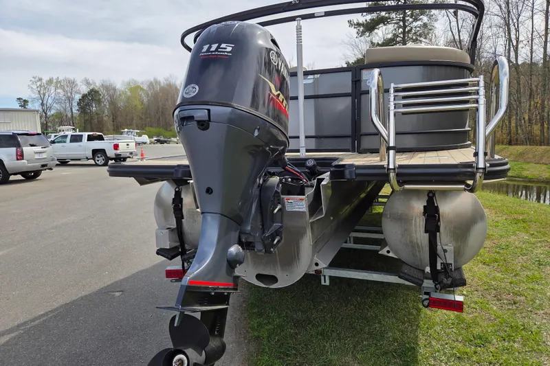 Slide: The Image of 2024 Starcraft EXS 1 pontoon boat with powerful 115 horsepower outboard motor, parked outdoors. - 3
