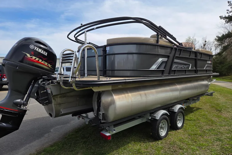 Slide: The Image of 2024 Starcraft EXS 1 pontoon boat with Yamaha engine on trailer, parked outdoors. - 4